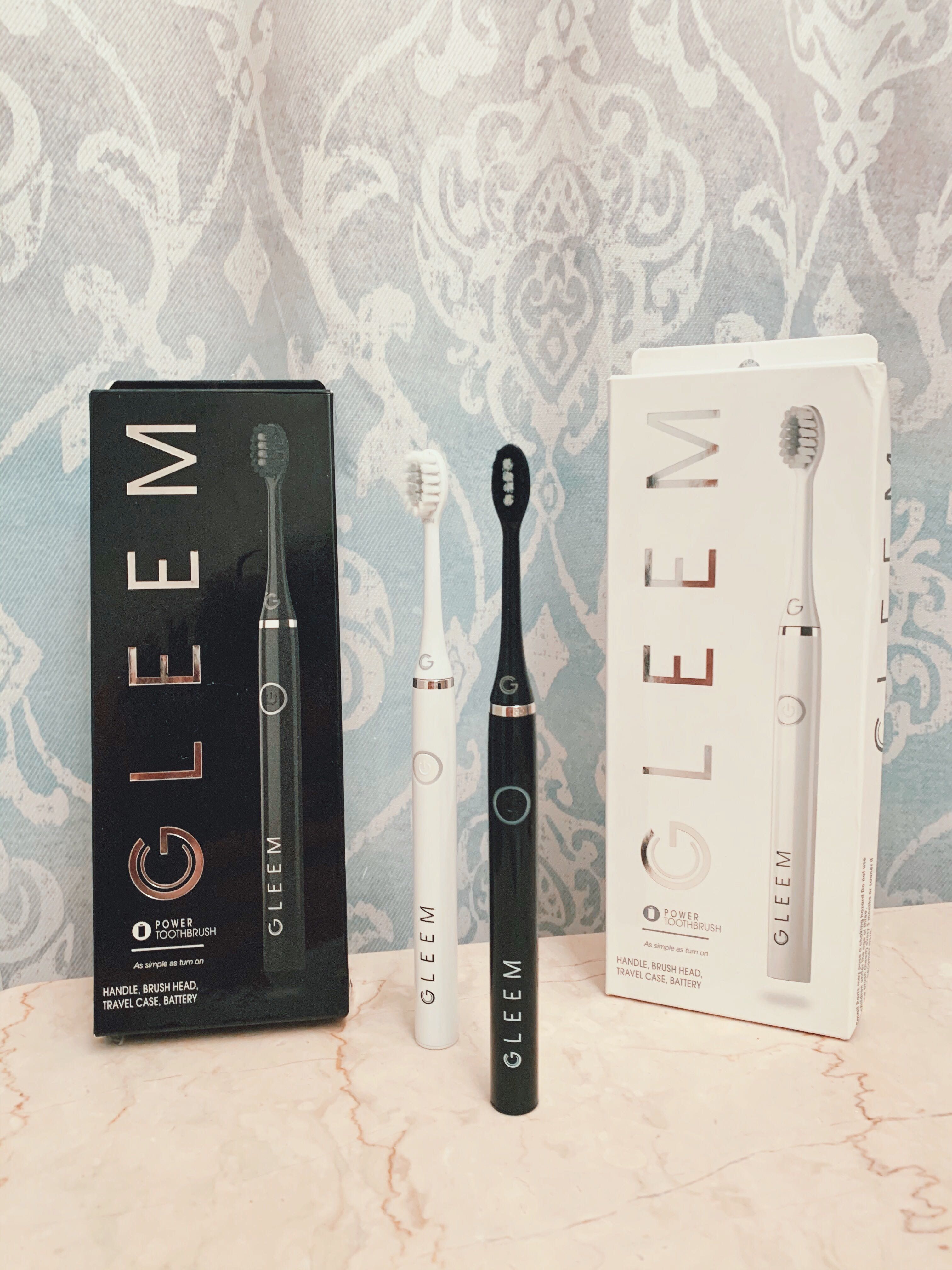 Black gleem electric toothbrush box and toothbrush on marble stone