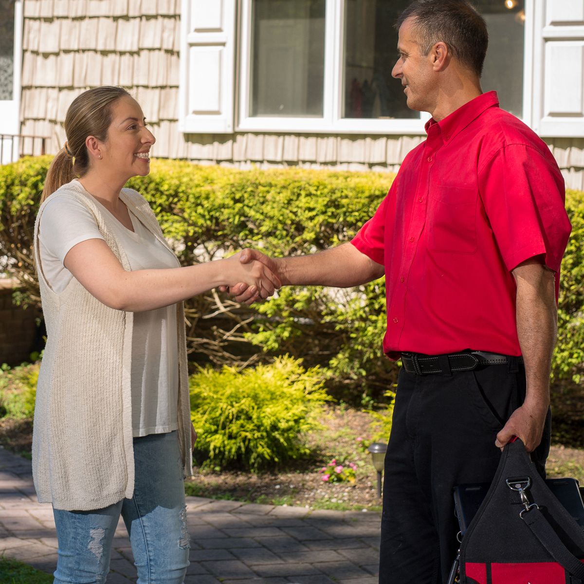 woman shaking a service mans hand outside her house