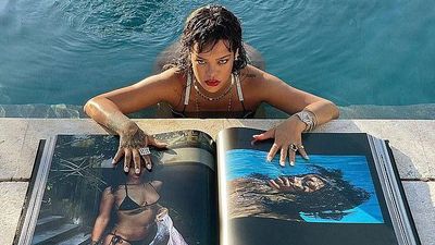 Rihanna posing with her book by the pool